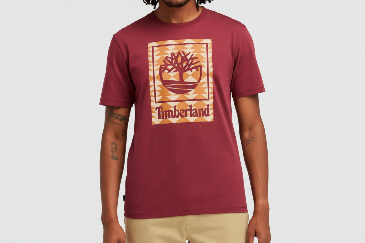 Maroon t-shirt with Timberland logo worn by a person on a white background